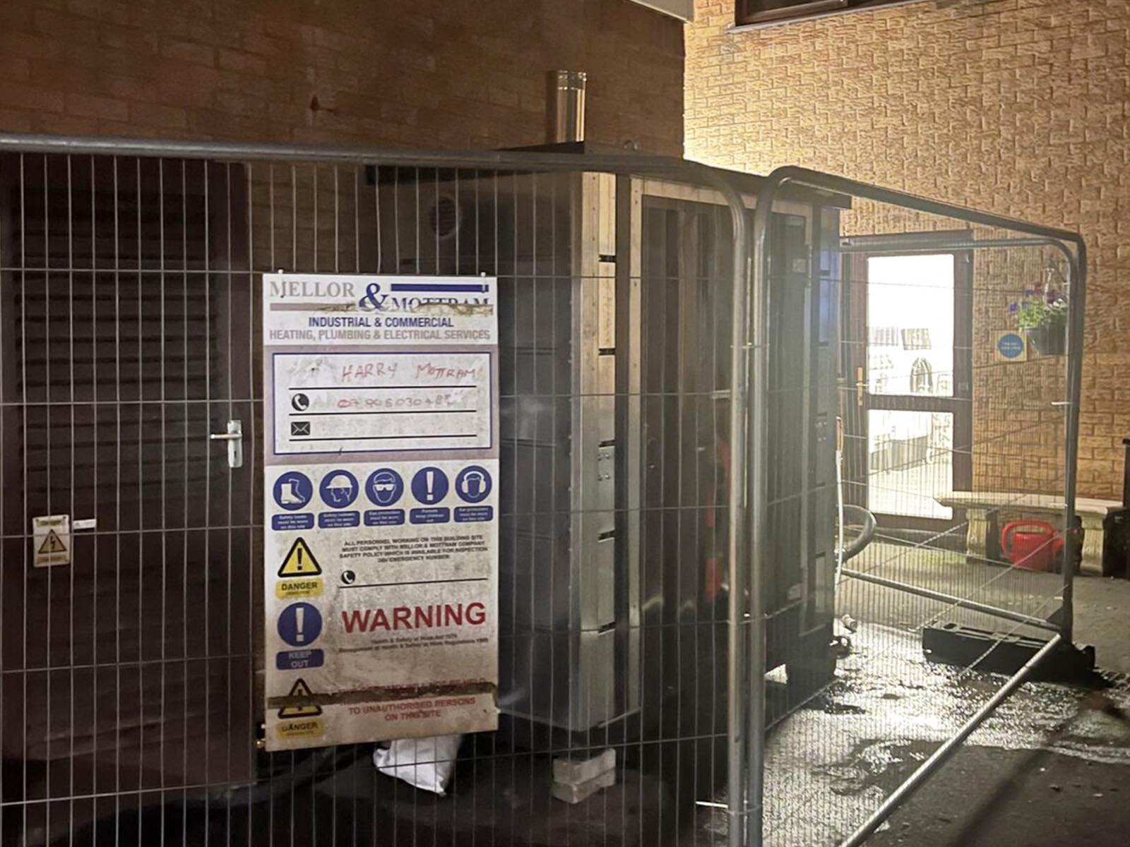 A temporary hire boiler installed and fenced beside a building overnight